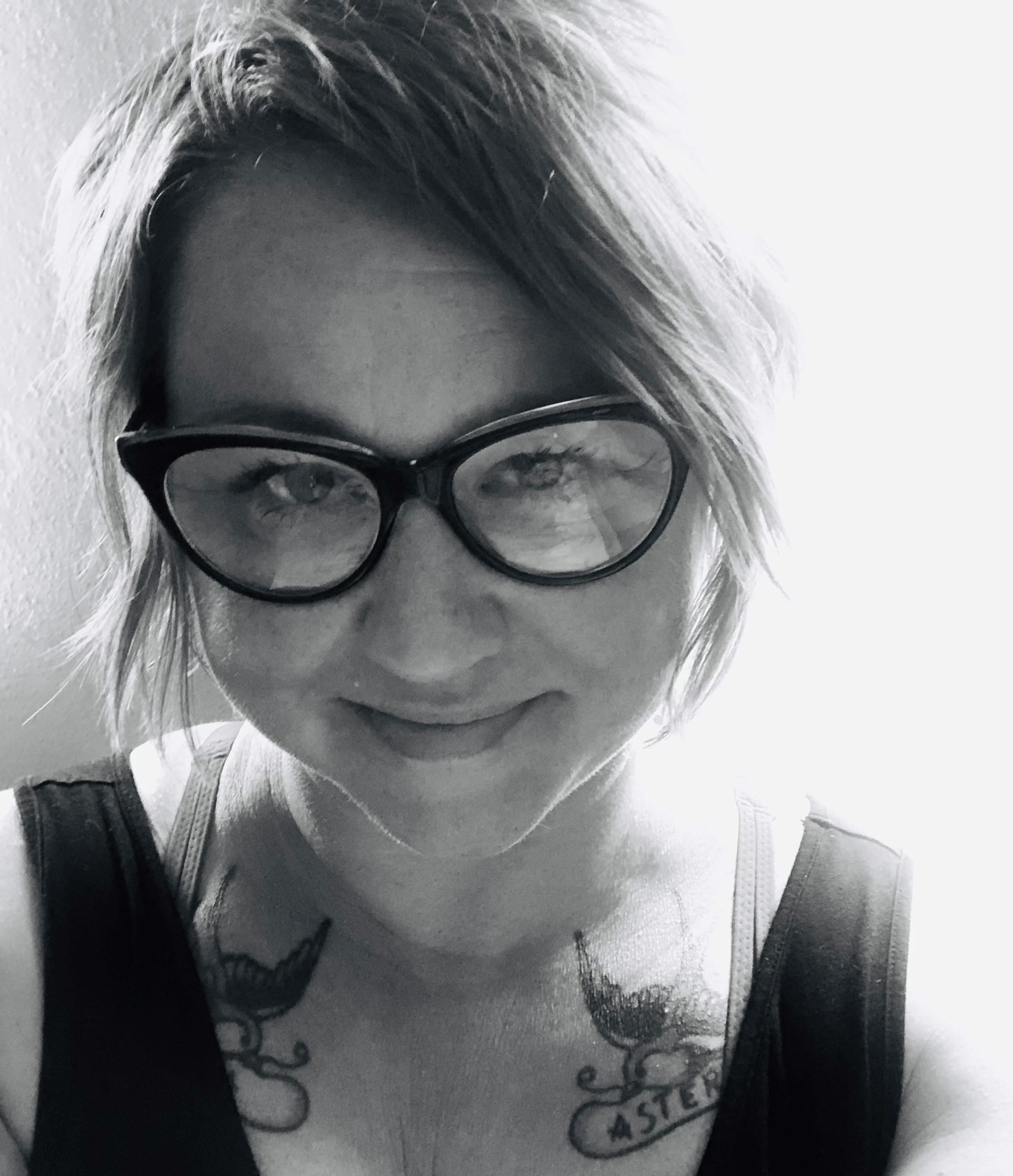 Black and white photo of a woman smiling, wearing glasses