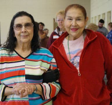 Two seniors with arms linked